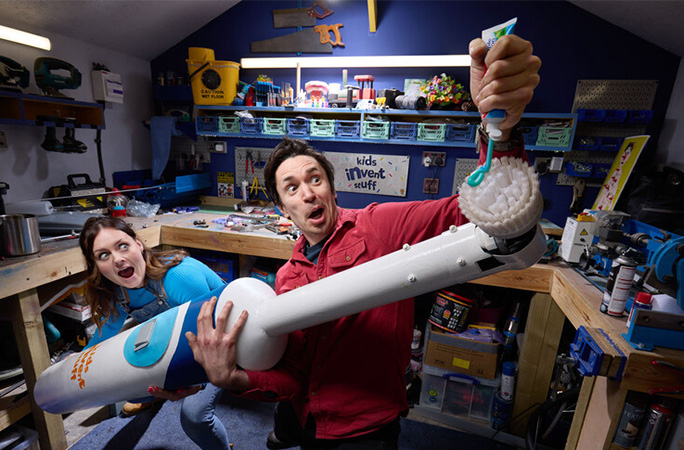 Ruth and Shawn holding the largest toothbrush and putting toothpaste on it
