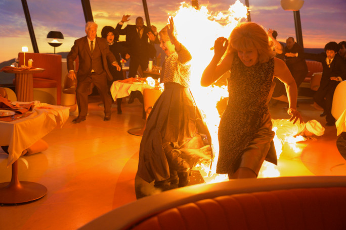 Yvette on fire, running past extras on the Final Destination set