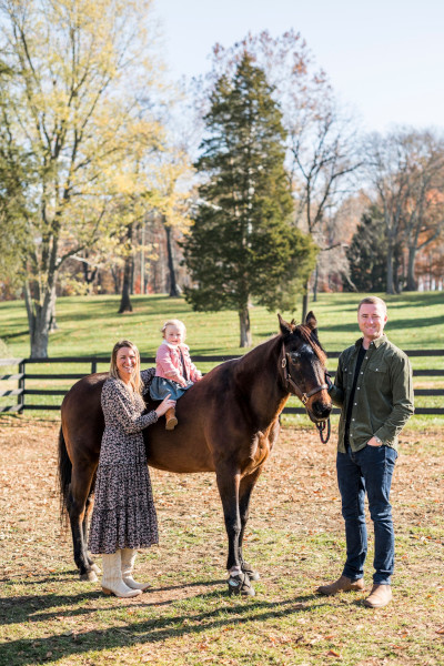 Paige's daughter riding Fancy with Paige and her husband