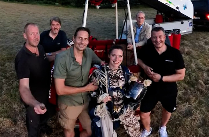 Marlene on the ground posing with her crew