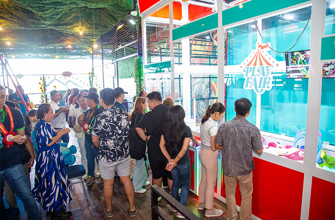 a crowd gathered round the largest claw machine