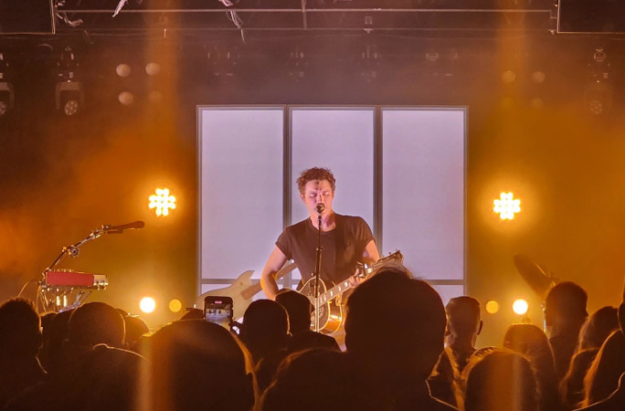 A musician performing in front of a white background