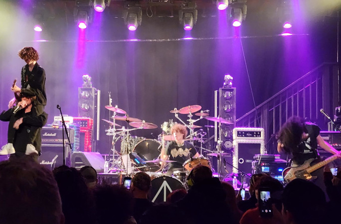 A singer on top of the guitarist's shoulders