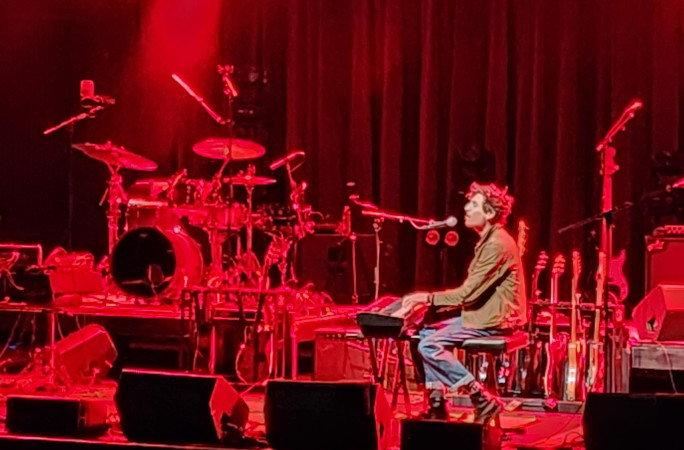 A singer playing the piano at a concert