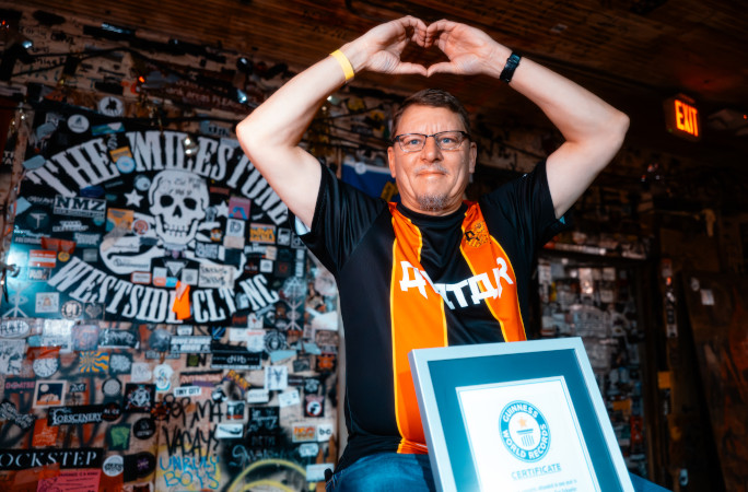 Tim throwing up a heart sign with his GWR certificate