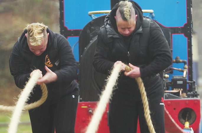 two strongwomen pulling a train