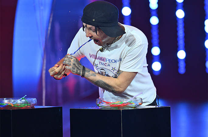 man pulling a balloon out of his nose