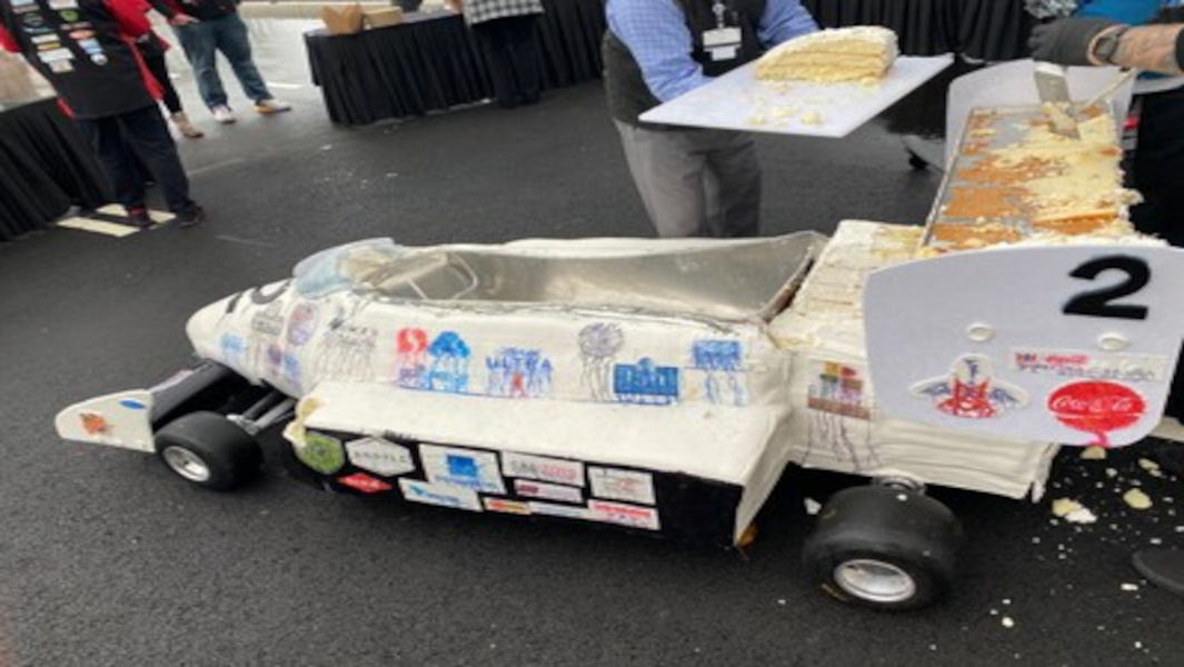 The car fully made of cake being cut in pieces
