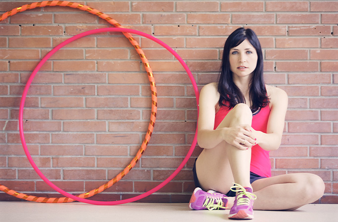 woman sitting next to hula hoops