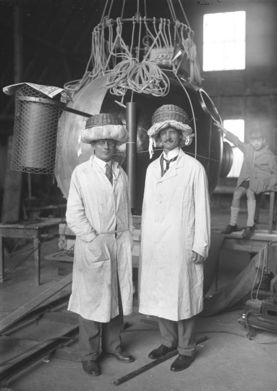 Auguste Piccard (right) and his assistant Paul Kipfer, posed in front of the revolutionary pressurized gondola of FNRS