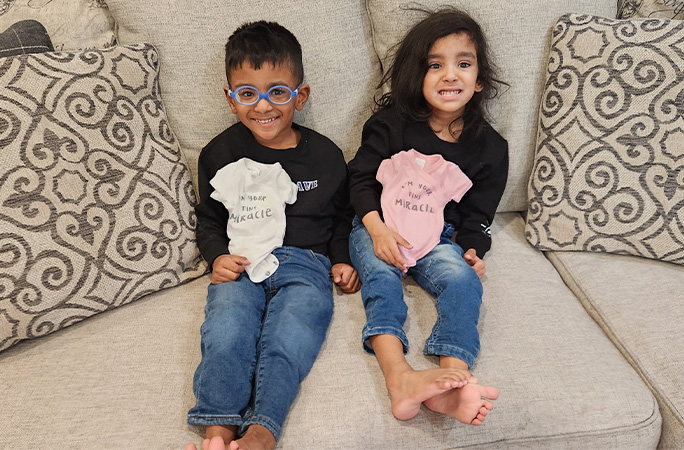 the prem twins holding their old baby grows