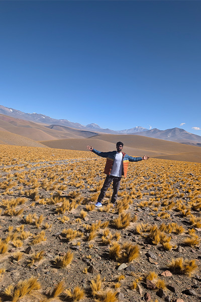 Anmish standing in a deserty looking field