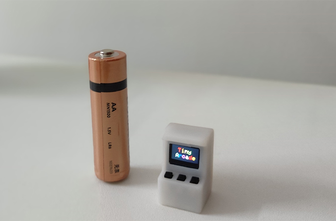 smallest arcade machine next to a battery