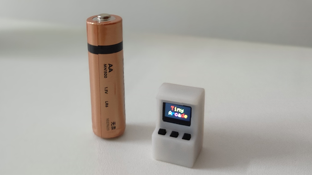 split image of smallest arcade machine next to a battery and on a laptop