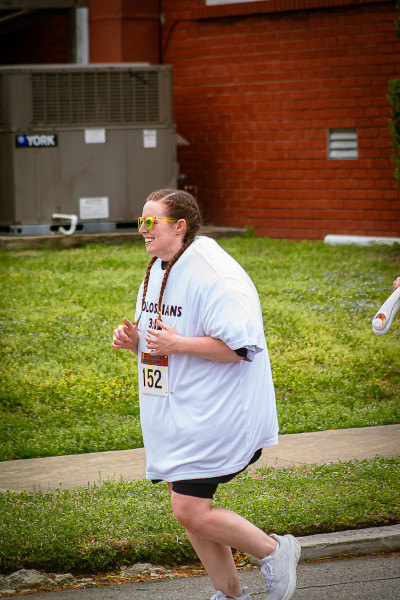 HD race photo of Meredith running with her shirts