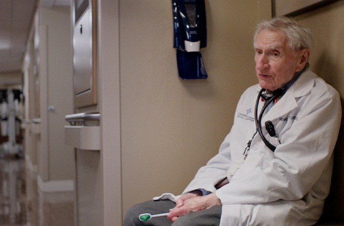 Dr Howard sitting in a hospital corridor