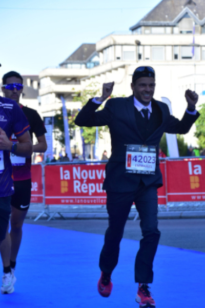 Emmanuel running in a suit