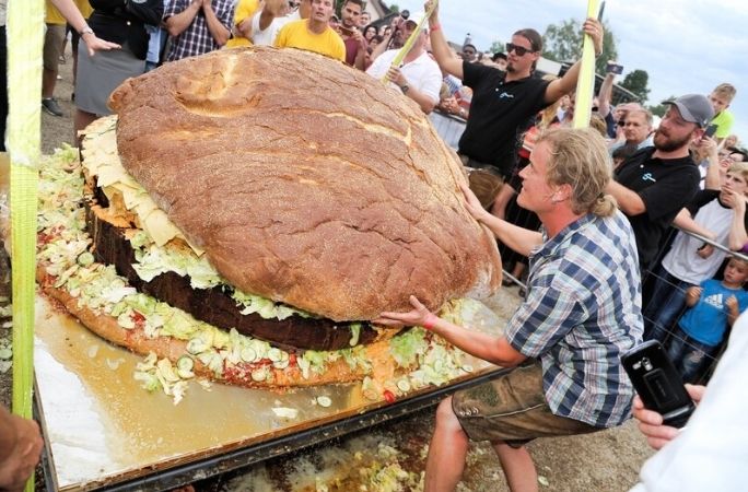 A man biting the largest hamburger