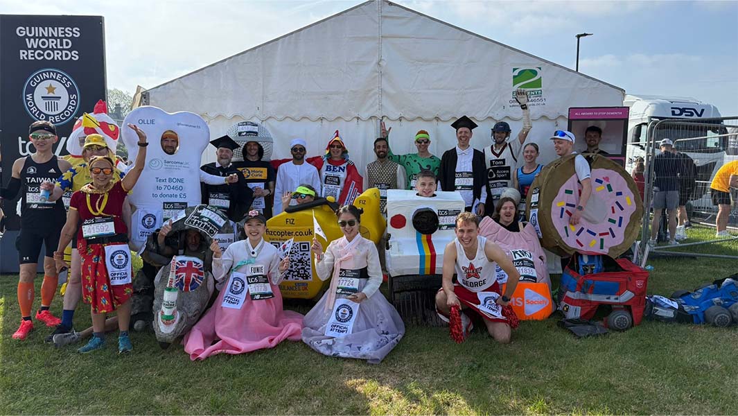 three split image of sabastian sawe and a runner dressed as optimus prime lying on his stomach besides a guinness world records certificate