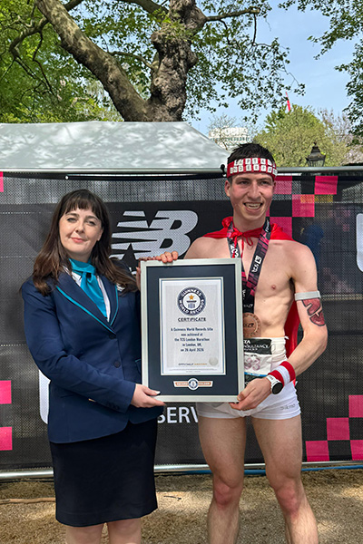 a man dressed up as captain underpants stands next to a guinness world records adjudicator