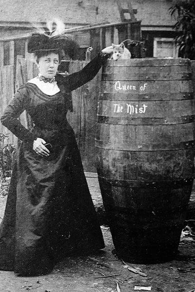 Annie with her barrel and a cat sitting on top of it