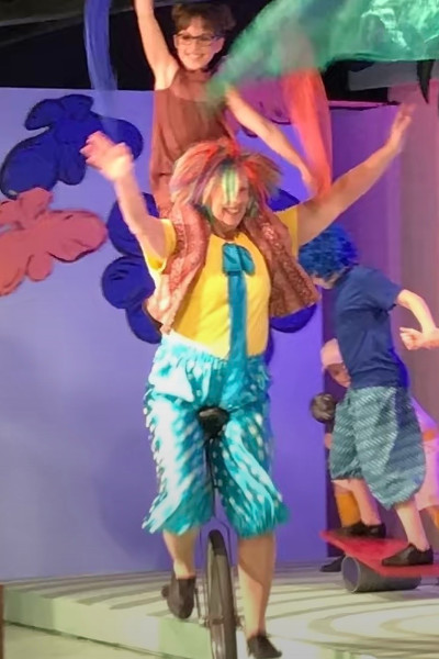 Linda performing at the Seussical with a kid on her shoulders