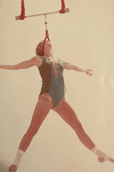 Linda hanging on the trapeze by her head