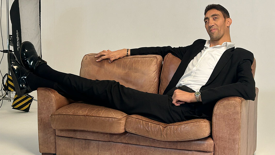 Sultan sitting on a sofa with his legs hanging off the other side