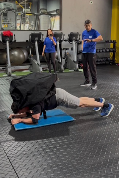 Fernando planking while a man in the background checks his watch