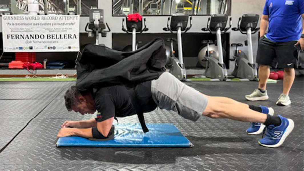 man planking with a 200 lb pack on his back