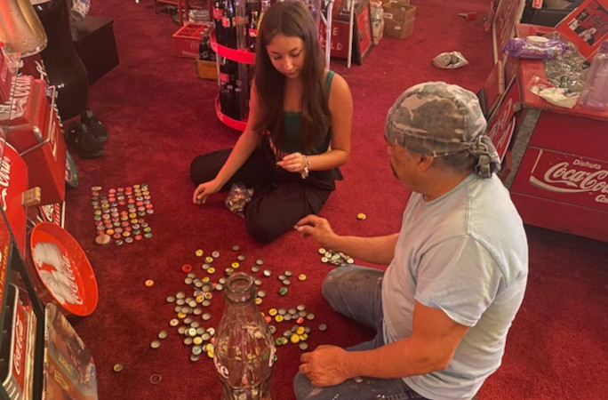 Bardo and a girl looking at bottle caps