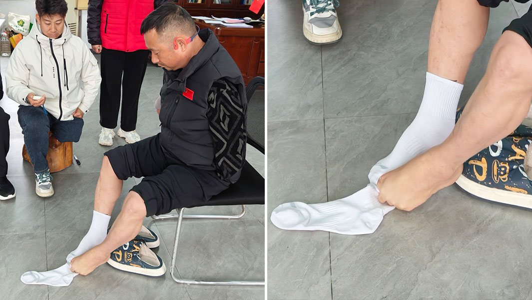 Li Fengqiang pulling on socks with his feet