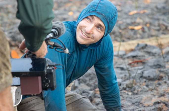 Antoine smiling while planting mangroves
