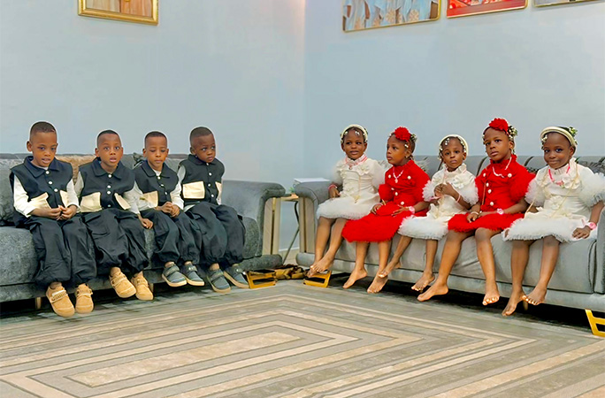 the nonuplets sitting on sofas