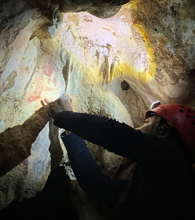 Oldest cave art Dr. Adhi Agus examining the artwork