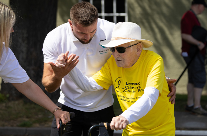 Harry walking with a helper
