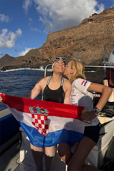 Dina getting a kiss while holding a Croatia flag