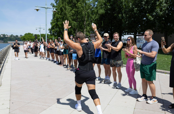 Austin with his arms in the air running past a line of people