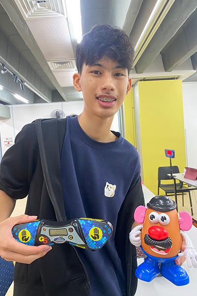 Calen Seah holding a Mr Potato Head and a SpeedStacks timer