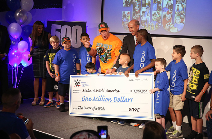 John Cena presenting a cheque to Make A Wish kids