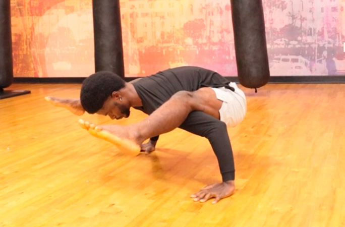 Dflex holding a firefly yoga pose