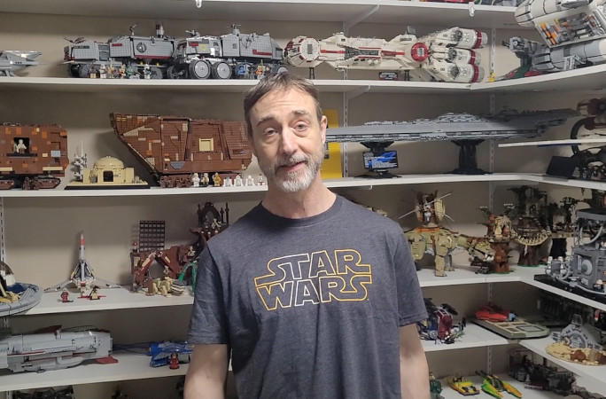 Fred standing in front of his LEGOs in the corner display
