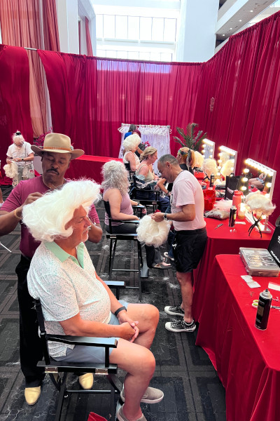 A man wearing a Marilyn wig getting a makeover in the boutique