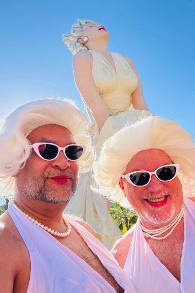 Two people dressed as Marilyn taking a selfie under the Marilyn statue