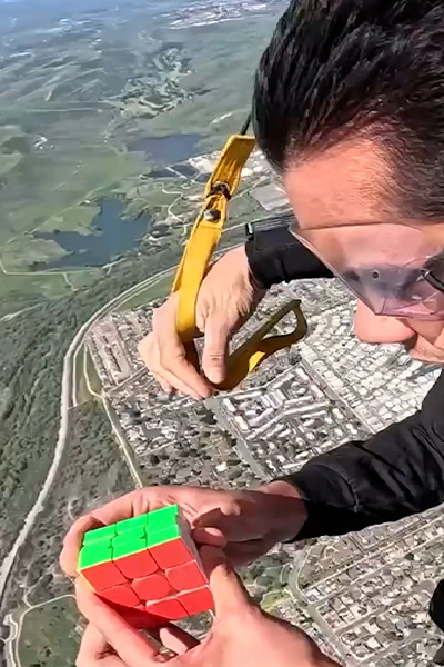 Ishaan solving a puzzle cube while skydiving