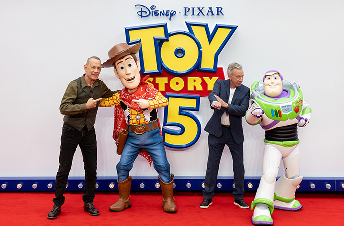 Tom Hanks and Tim Allen posing with their characters on the Toy Story 5 red carpet StillMovingNet Shutterstock