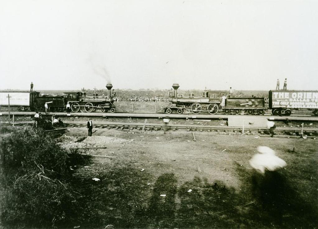 A black and white photograph of two steam locomotives facing each other on a single length of track.