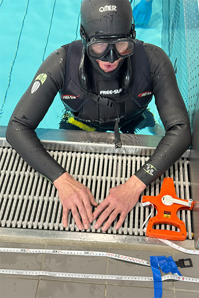 Stanislaw catching his breath with his arms up on the side of the pool