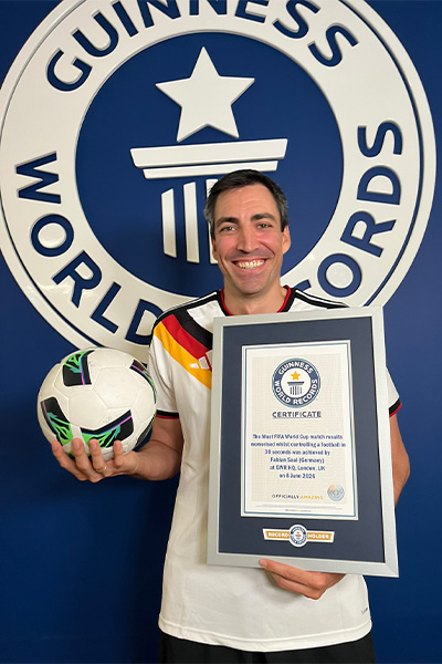 Fabian holding a football and a certificate