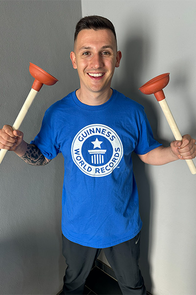 Andre posing with two plungers